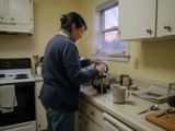An adult making coffee in a quiet kitchen in the morning