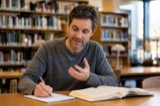 An adult working through an example with a notebook at a library table