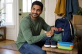 A father preparing a small backpack and lunchbox for the day