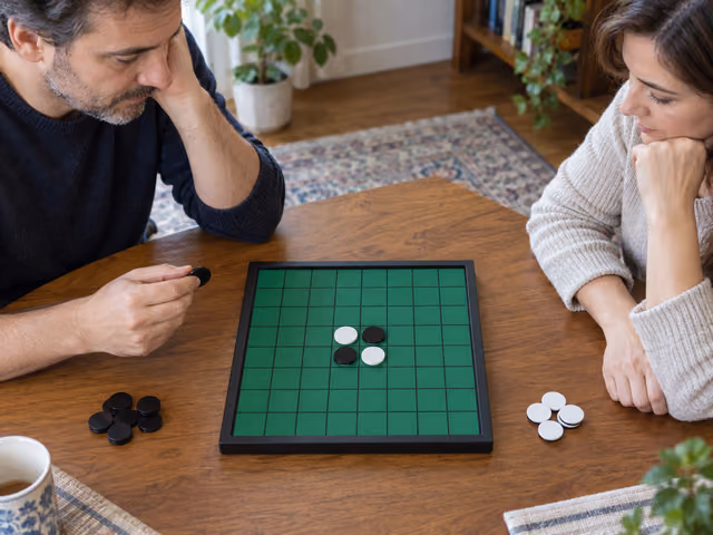 Two adults study the four-disc opening on a Reversi board