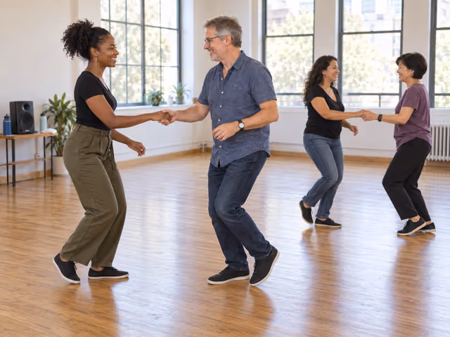 Two adult pairs practicing small partner swing steps with relaxed hand connections on a clear studio floor.