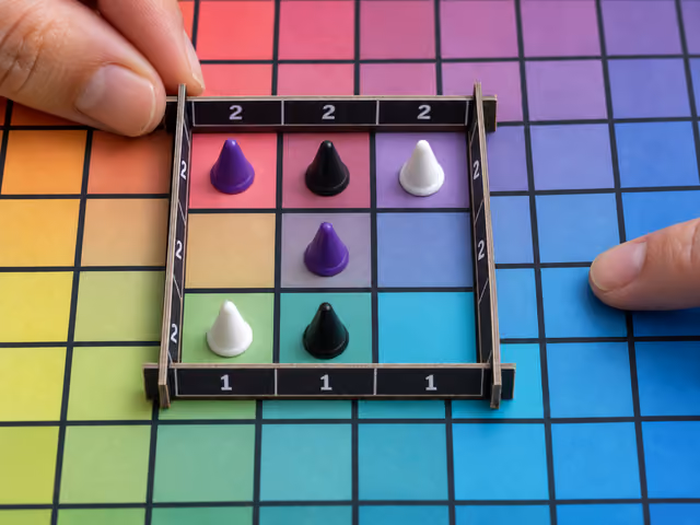 Six cone markers on separate color squares within an upright three-by-three scoring frame during a Hues and Cues game.