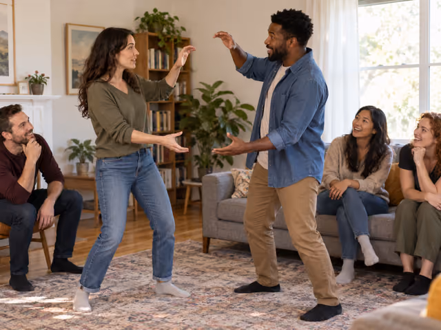 Two adults acting out a scene with empty-handed gestures while three seated friends watch.