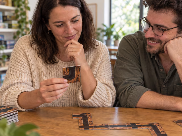 Adults considering a tunnel card beside a connected path of cards.