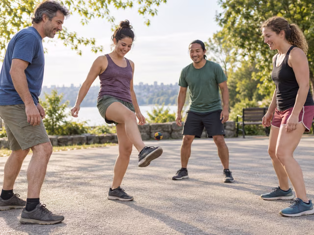 Adults in a park keeping a small footbag in the air.