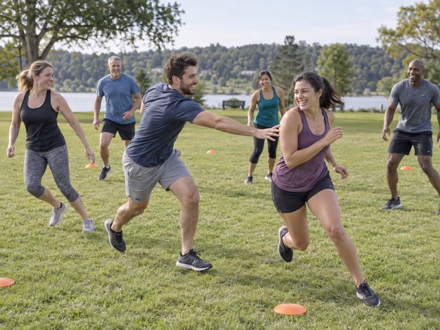 Adults playing a running tag game on an open lawn.